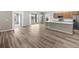 Spacious open-concept living area featuring modern kitchen with stainless steel appliances and wood laminate flooring at 723 Bentley North Loop, Auburndale, FL 33823