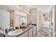 Well-lit bathroom with double sinks, ample counter space, and a bathtub with tiled surround at 7525 Jessamine Dr, Lakeland, FL 33810