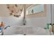 Bright bathroom featuring a corner bathtub with tiled walls and nautical-themed decorations near a frosted glass window at 7525 Jessamine Dr, Lakeland, FL 33810