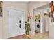 Welcoming foyer with a decorative front door, tile flooring, and a view into the laundry room at 7525 Jessamine Dr, Lakeland, FL 33810