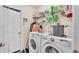 Functional laundry room featuring a side-by-side washer and dryer and overhead shelving for storage at 7525 Jessamine Dr, Lakeland, FL 33810