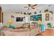 Cozy living room with vaulted ceilings, ceiling fan, comfortable seating, and decor shelves at 7525 Jessamine Dr, Lakeland, FL 33810