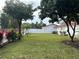 View of the back yard showing the lawn, landscaping and the back of the home at 1323 Valley E Hl, Lakeland, FL 33813