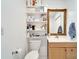 Small bathroom with a toilet, sink, vanity, mirror, and shelving for storage at 1323 Valley E Hl, Lakeland, FL 33813