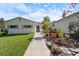 Landscaped front yard featuring a charming home with gray shutters and a welcoming pathway to the front door at 1323 Valley E Hl, Lakeland, FL 33813
