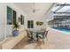 A covered outdoor patio features a table and chairs, with a pool visible in the background at 1323 Valley E Hl, Lakeland, FL 33813