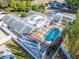 Aerial view of a screened-in pool with a large pool deck and adjacent to the home at 1323 Valley E Hl, Lakeland, FL 33813