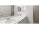 A bright bathroom featuring double sinks, a sleek shower, and neutral finishes throughout the space at 305 Wharf Way, Winter Haven, FL 33881