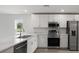 Sleek kitchen featuring marble counters, stainless steel appliances, and ample cabinet space at 305 Wharf Way, Winter Haven, FL 33881