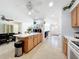 Open kitchen with light wood island, breakfast bar, and views to dining and living areas at 309 W Frederick Ave, Dundee, FL 33838