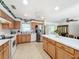 Bright kitchen features wood cabinets, white appliances, and an island, complemented by a view from the window at 309 W Frederick Ave, Dundee, FL 33838