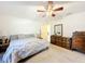 Spacious main bedroom with carpet floors, a ceiling fan, large dresser and an ensuite bath at 309 W Frederick Ave, Dundee, FL 33838