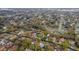 Overhead view of a house nestled in mature trees, located in a quiet neighborhood with a pond nearby at 3845 Garnet Dr, Mulberry, FL 33860