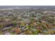 Aerial view of a house with mature tree coverage and a nearby lake in a charming residential neighborhood at 3845 Garnet Dr, Mulberry, FL 33860