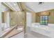 Bright bathroom boasting a vanity, soaking tub, window with blinds, and walk-in closet at 3845 Garnet Dr, Mulberry, FL 33860