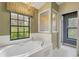 Bathroom features a luxurious tub with chandelier and shower, and a large window that offers natural light at 3845 Garnet Dr, Mulberry, FL 33860