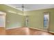 Open Primary bedroom featuring wood floors, a ceiling fan, and two windows with neutral curtains at 3845 Garnet Dr, Mulberry, FL 33860