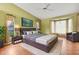 Comfortable bedroom featuring hardwood floors, a large bed, and stylish decor at 3845 Garnet Dr, Mulberry, FL 33860