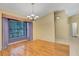 Bright dining area with hardwood floors, large window, and modern chandelier at 3845 Garnet Dr, Mulberry, FL 33860