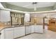 Bright kitchen with white cabinets, a window with views, and tiled floors that open to living room at 3845 Garnet Dr, Mulberry, FL 33860