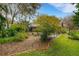 Landscaped backyard features a screened-in pool, lush greenery, and mature trees, offering a private outdoor retreat at 3845 Garnet Dr, Mulberry, FL 33860
