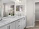 Bathroom with double sinks, marble countertops, white cabinets, and a framed mirror at 5105 Sylas Jax Ave, Winter Haven, FL 33884