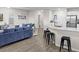 Open floor plan showcasing kitchen island, living room with stylish blue sofas, and dining area at 5105 Sylas Jax Ave, Winter Haven, FL 33884