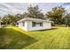 A charming one-story white home with green shutters surrounded by a lush green lawn and mature trees at 561 Cameo Dr, Lakeland, FL 33803
