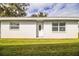 Front view of a single story house with white walls and green lawn at 561 Cameo Dr, Lakeland, FL 33803