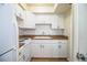 The kitchen has all white appliances, ample cabinet space, and wood-look floors at 561 Cameo Dr, Lakeland, FL 33803