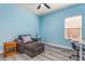 Bright bedroom with light blue walls, hardwood floors, and a comfy lounging chair at 185 St Thomas Dr, Mulberry, FL 33860