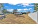 Large backyard with dry grass and a white vinyl fence at 3107 Valley High Dr, Lakeland, FL 33813