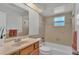Bathroom with tub, wood vanity, and window at 3107 Valley High Dr, Lakeland, FL 33813
