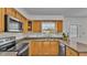 View of kitchen with wood cabinets, granite countertops, and stainless steel appliances at 3107 Valley High Dr, Lakeland, FL 33813