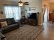 Bright living room featuring a ceiling fan, large sectional sofa, and sliding glass doors at 3604 Julius Estates Blvd, Winter Haven, FL 33881