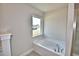 Bright bathroom with soaking tub under window and tiled shower to the side at 4036 Tullamore Ln, Auburndale, FL 33823