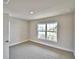 Bright bedroom with a large window, carpeted floor, and neutral wall paint at 4036 Tullamore Ln, Auburndale, FL 33823