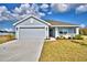 Charming single-story home with a gray exterior, a two-car garage, and a well-manicured front lawn at 4036 Tullamore Ln, Auburndale, FL 33823