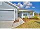 Close-up of the light-blue home's front exterior, featuring the front door and a two-car garage at 4036 Tullamore Ln, Auburndale, FL 33823