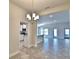 Bright, open-concept living space features a modern chandelier and tile flooring at 4036 Tullamore Ln, Auburndale, FL 33823