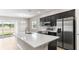 Modern kitchen with stainless steel appliances, dark cabinets, a large island, and hardwood floors at 715 Sw 77Th Cir, Ocala, FL 34474