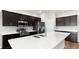 Modern kitchen featuring stainless steel appliances, dark cabinetry, and a large center island with a double sink at 715 Sw 77Th Cir, Ocala, FL 34474