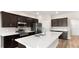 Modern kitchen featuring stainless steel appliances, dark cabinetry, and a large center island with a double sink at 715 Sw 77Th Cir, Ocala, FL 34474