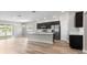 Modern kitchen with stainless steel appliances, dark cabinets, a large island, and hardwood floors at 715 Sw 77Th Cir, Ocala, FL 34474