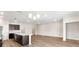 A spacious room with hardwood floors, recessed lighting, and a kitchen with dark cabinets and stainless steel appliances at 715 Sw 77Th Cir, Ocala, FL 34474