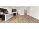 A spacious room with hardwood floors, recessed lighting, and a kitchen with dark cabinets and stainless steel appliances at 715 Sw 77Th Cir, Ocala, FL 34474