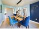 Elegant dining room featuring a unique wood and glass table with blue velvet chairs at 1155 Towergate Cir, Lake Wales, FL 33853