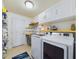 Efficient laundry room with updated washer and dryer, white cabinetry, and wash basin at 1155 Towergate Cir, Lake Wales, FL 33853