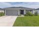 One-story home with gray exterior, attached garage, and landscaped front yard at 1225 Third Ct, Eagle Lake, FL 33839