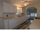 Well-lit kitchen features all white cabinets, ample counter space, and updated laminate flooring at 1610 Reynolds Rd # 211, Lakeland, FL 33801